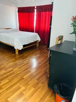 a room with a bed and a red curtain at ENEDE HOSTEL in Cusco