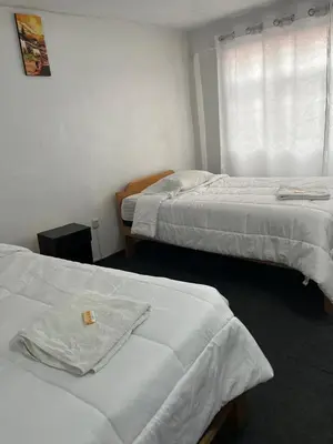a hotel room with two beds and a window at ENEDE HOSTEL in Cusco