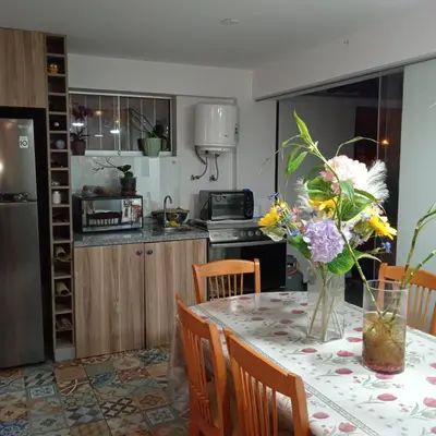 a kitchen with a table with a vase of flowers on it at DEPARTAMENTO RECAVARREN (SURQUILLO/MIRAFLORES) in Lima