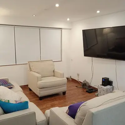 a living room with two couches and a flat screen tv at DEPARTAMENTO RECAVARREN (SURQUILLO/MIRAFLORES) in Lima
