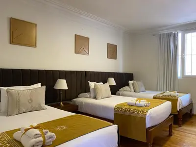 a hotel room with two beds and two tables at Katari at Plaza de Armas Cusco in Cusco