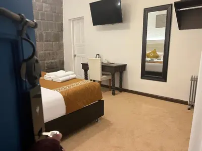 a bedroom with a bed and a desk and a mirror at Katari at Plaza de Armas Cusco in Cusco