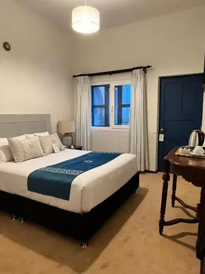 a bedroom with a bed and a table and a window at Katari at Plaza de Armas Cusco in Cusco