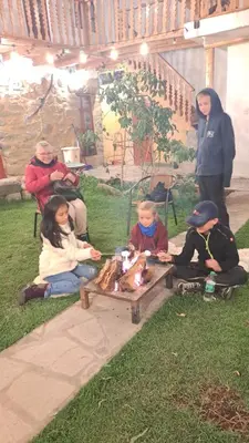 a group of children sitting on the grass with a dog at Luisa in Ollantaytambo