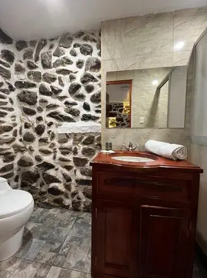 a bathroom with a sink and a stone wall at Luisa in Ollantaytambo