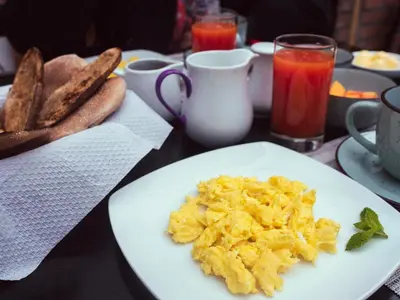 a plate of scrambled eggs on a table with toast at Luisa in Ollantaytambo