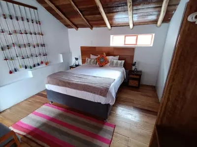 a bedroom with a bed and a rug on the floor at Luisa in Ollantaytambo