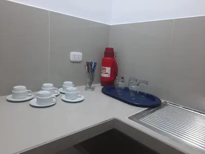 a kitchen counter with cups and saucers on it at Hospedaje Margarita in La Merced