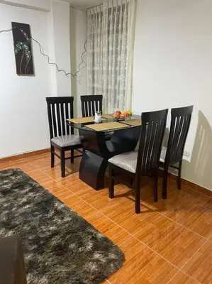 a dining room with a table and four chairs at Departamento D&C I entero acogedor in Huancayo