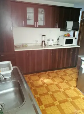 a kitchen with wooden cabinets and a counter top at Departamento D&C I entero acogedor in Huancayo