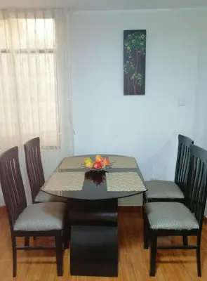 a dining room table and chairs with a bowl of fruit on it at Departamento D&C I entero acogedor in Huancayo