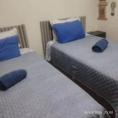 two beds with blue pillows in a room at Barranco monumental in Lima