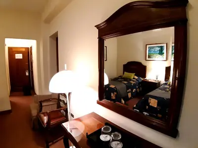 a room with a mirror and a bed and a table at Hotel MAURY in Lima