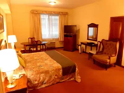 a hotel room with a bed and a chair at Hotel MAURY in Lima