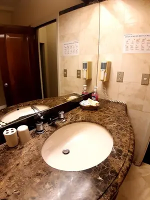 a bathroom counter with a sink and a mirror at Hotel MAURY in Lima