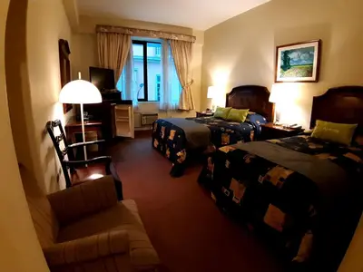 a hotel room with two beds and a couch at Hotel MAURY in Lima