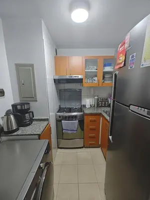 a kitchen with a refrigerator and a stove top oven at Dpto PARQUE SAN FELIPE in Lima