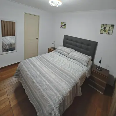 a bedroom with a large bed with a gray blanket at Dpto PARQUE SAN FELIPE in Lima