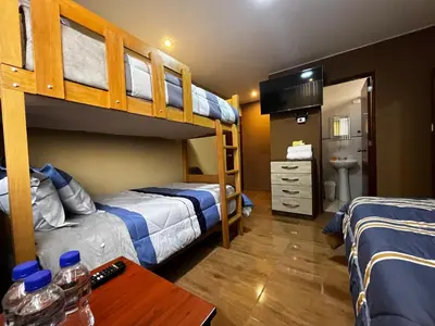 a bedroom with two bunk beds and a desk at Matty House in Lima