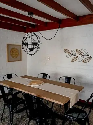 a room with a table with chairs and a chandelier at Vistamar Duplex in Lima