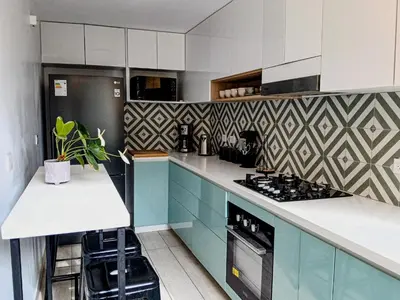 a kitchen with blue cabinets and white counter tops at Vistamar Duplex in Lima