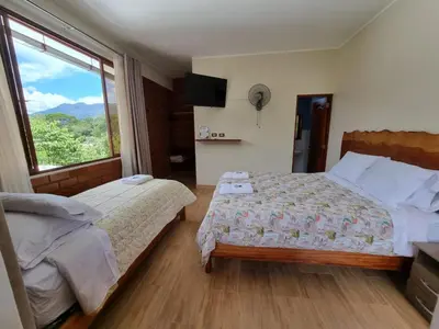 a bedroom with two beds and a window at Pampa Bella Lodge in La Merced