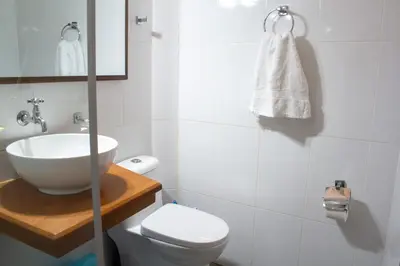 a white bathroom with a sink and a toilet at Apartamento Altoandino in Ayacucho