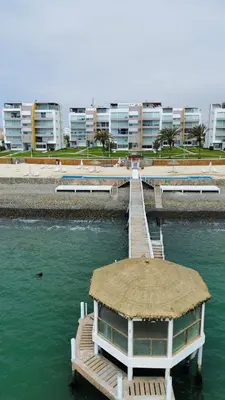a dock in the water with a building in the background at Suite 1 Fila Vista Bahía Paracas- La Velas 601 T1 in Paracas