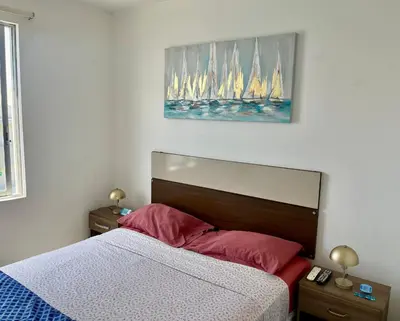 a bedroom with a bed with sailboats on the wall at Suite 1 Fila Vista Bahía Paracas- La Velas 601 T1 in Paracas