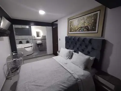 a bedroom with a large bed and a bathroom at Hostal El Edén Huaral in Huaral