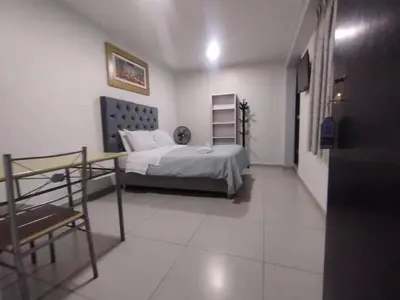 a bedroom with a bed and a chair in a room at Hostal El Edén Huaral in Huaral