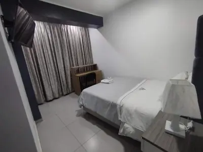 a hotel room with a bed and a window at Hostal El Edén Huaral in Huaral