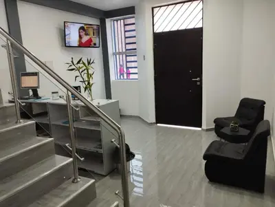 a office with a black door and a chair at Hostal El Edén Huaral in Huaral