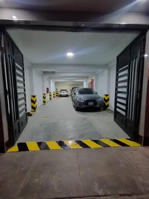 a parking garage with two cars parked in it at Hostal El Edén Huaral in Huaral