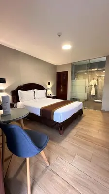 a bedroom with a bed and a table and a chair at Serenzza Hotel in Lima