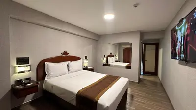 a hotel room with a large bed and a television at Serenzza Hotel in Lima