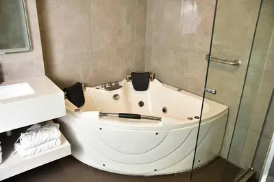 a bath tub in a bathroom with a glass shower at Serenzza Hotel in Lima