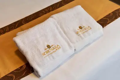 two white napkins with gold embroidery on them at Serenzza Hotel in Lima