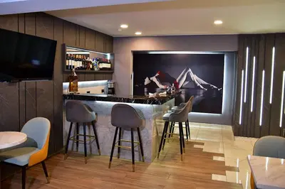a bar in a restaurant with stools and a tv at Serenzza Hotel in Lima