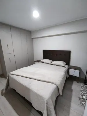 a bedroom with a large bed with white sheets at Epiqe Manuel Olguin 600 in Lima