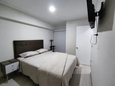 a white bedroom with a bed and a door at Epiqe Manuel Olguin 600 in Lima