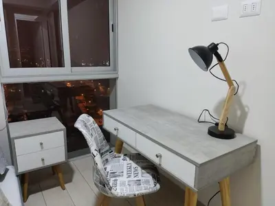 a desk with a lamp and a chair next to a window at Epiqe Manuel Olguin 600 in Lima
