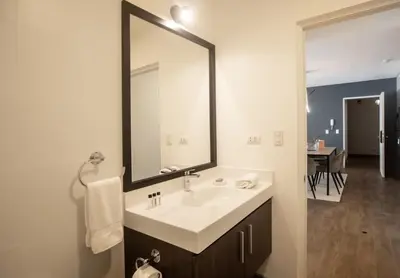 a bathroom with a sink and a large mirror at SoHo by Wynwood House in Lima
