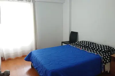 a bedroom with a blue bed and a window at Elegante Flat en inmejorable ubicación - San Isidro in Lima
