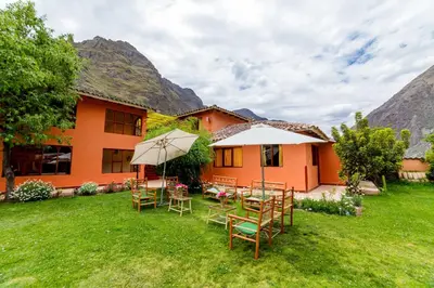 a house with tables and chairs in the yard at LILIUM VALLEY in Ollantaytambo