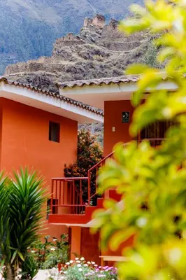a house with a staircase in front of a mountain at LILIUM VALLEY in Ollantaytambo