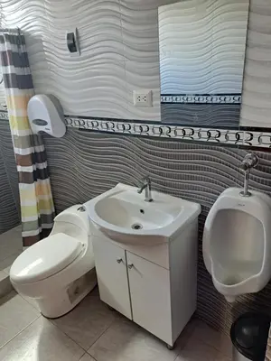 a bathroom with a toilet and a sink and a urinal at Maychu's Albergue in Chinchero