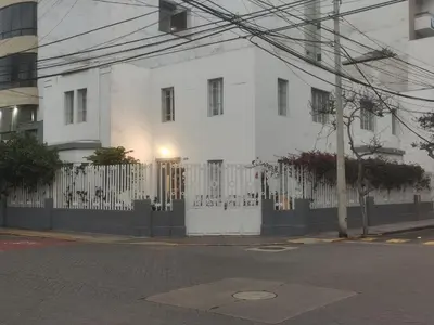 a white building with a fence in front of it at La Casona Hospedaje in Lima