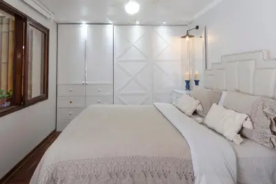 a bedroom with a large bed with white walls at Casa Ramos Salamanca - Airport pick up and drop off service - Homestay in Lima