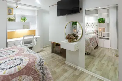 a bedroom with a bed and a mirror and a desk at Casa Ramos Salamanca - Airport pick up and drop off service - Homestay in Lima
